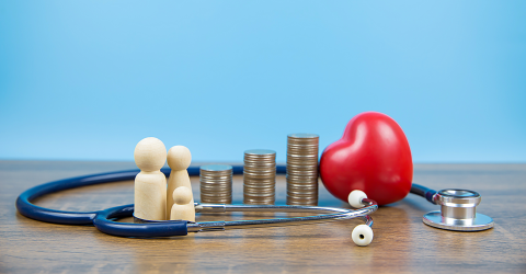 Miljoenennota 2027 zorgpremie; poppetjes, stapels muntgeld, hart en stethoscoop met een blauwe achtergrond